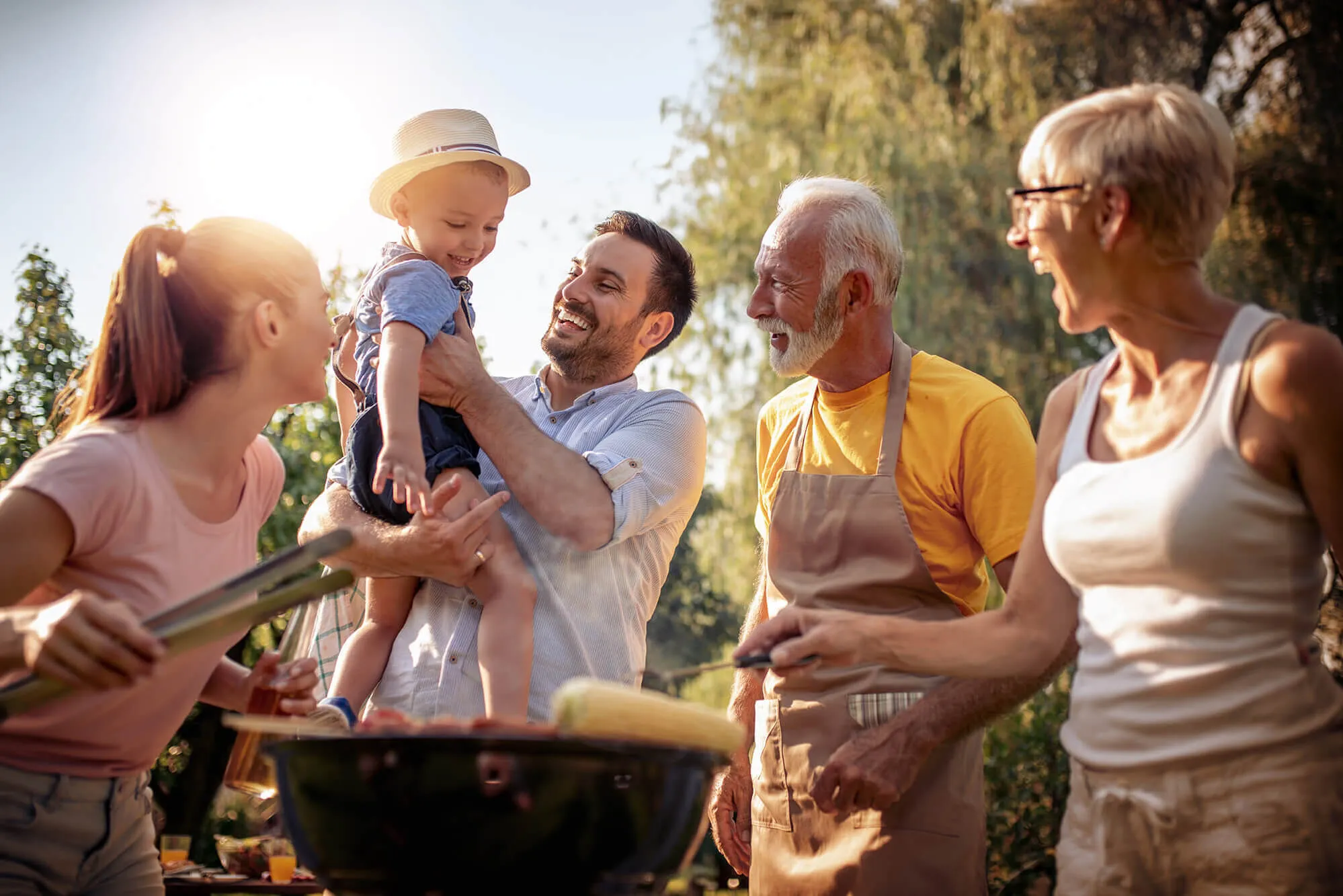 Happy family having barbecue party in backyard